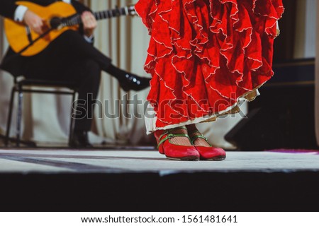 Flamenco dancer legs in red shoes on stage Royalty-Free Stock Photo #1561481641