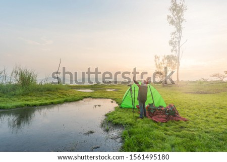 Asian person camping and taking pictures in the morning. Sun rise Asian river belt.