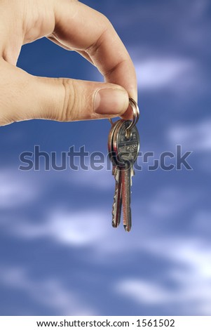 Young hand with keys on clouds background