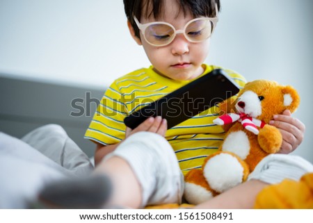 cute child little boy using digital tablet or smart phones for playing games and watching cartoons, smart phone mobile addiction technology communication lifestyles.
