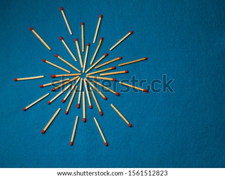 Symbol of sun made out of matches on blue background 