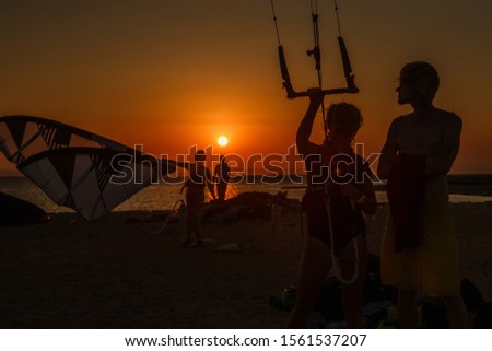 Photo of kite surfers at sunset