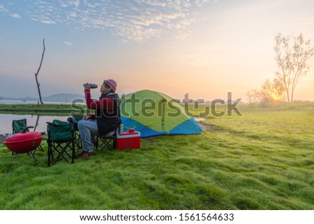 Asian people come to camping. And take pictures in the morning The sunrise on the asian river on holiday