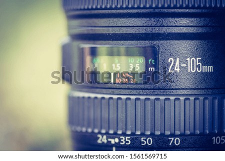 Close up picture of a professional optic photo lens. Smooth blurry background, warm colors. 