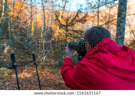 Nature photographer take a picture in the autumn forest