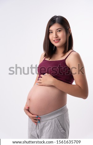 Close up of modern asian pregnant belly,beautiful expectant tander lovely mother stand and hold belly.She waiting for birth of baby.