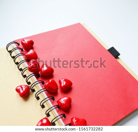 red hearts are scattered on the red sheet of the diary