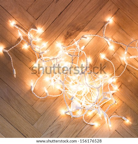 Christmas lights  garland on a old antique wooden parquet floor, top view.
