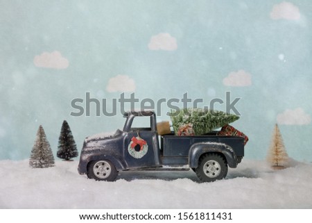 Bottle brush Christmas tree on a toy truck in a winter scene