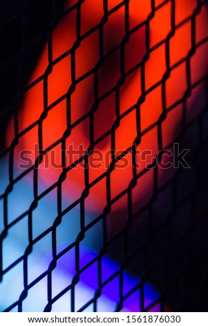 Background picture. Neon lights through a fence.