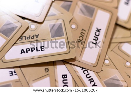 Apple and luck word on a yellow card, shallow depth of field. Multiple cards visible out of focus. Focus on luck. Luck of apple