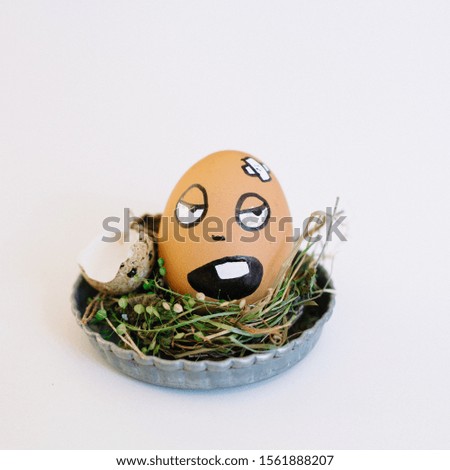 A depiction of a funny injured face on an egg in a cute small plate on a white background