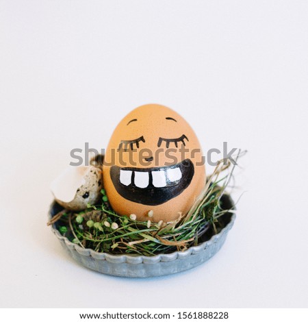 A depiction of a funny face with closed eyes on an egg in a cute small plate on a white background