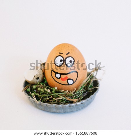 A depiction of an angry face on an egg in a cute small plate on a white background
