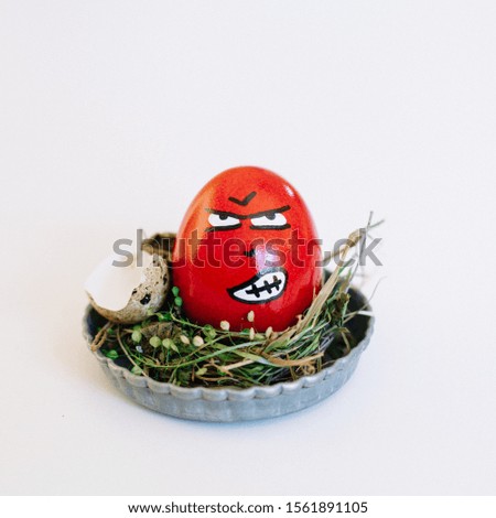 A depiction of an angry face on a red egg in a cute small plate on a white background