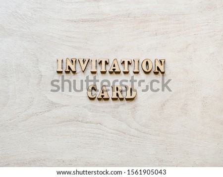 Beautiful card with unpainted wooden letters lying on a white board. Top view, close-up. Isolated background