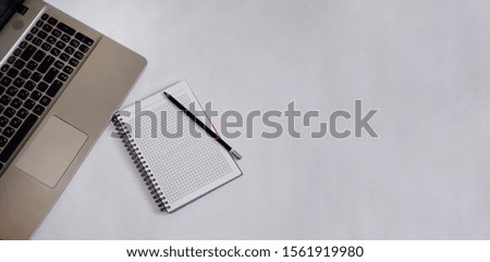 Notebook with pen and notebook on the desktop accountant. A spiral notebook with a laptop computer on a clean white Desk. Wide-angle and panoramic photos. Copy space, flat lay, top view, mock up.