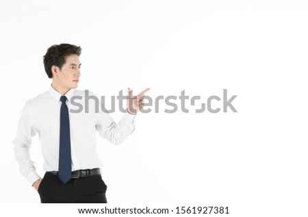 Portrait of confident man smiles, arms in pocket, points finger to the right, isolated on white background with copy space. For motivation, finance, business, achievement and entrepreneur concept