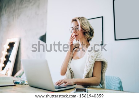 Surprised female remote worker watching online video vlog on media website for blogging and amazed with received funny information, Caucasian woman in spectacles using 4g wireless for networking
