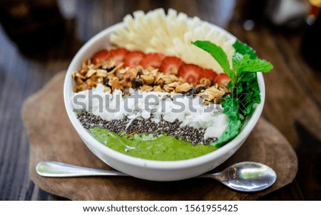 

Healthy breakfast bowl: tropical fruits smoothie with chia seeds,  banana pineapple, green matcha. Healthy food concept. Flat lay, top view, close up
