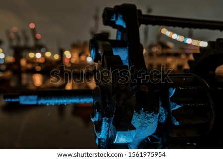 A closeup shot of an iron mechanism construction with bokeh lights in the background