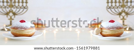 religion image of jewish holiday Hanukkah with spinning top and doughnut over white background