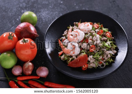 Winged Bean Salad, spicy flavor, typical of Thai food In a black plate, black wood floor