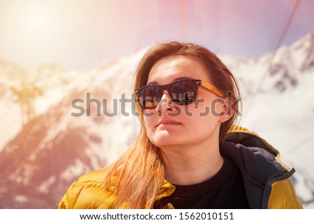Woman in sunglasses portrait in the white snow mountains