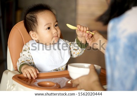 A Little baby boring eating In High Chair