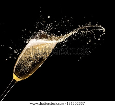Glass of champagne with splash, isolated on black background Royalty-Free Stock Photo #156202337