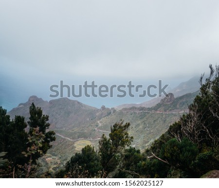 Ocean view merging with the horizon due to heavy fog and the surroundings with green tropic forests among the hills and serpentine
