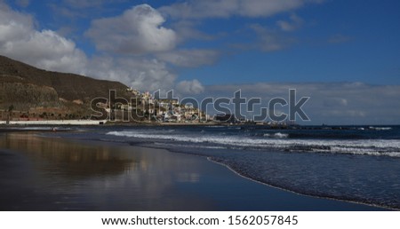Sandy beach with low tide, sky with clouds and city, La Laja, Las Palmas de Gran Canaria, Spain