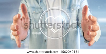 View of a Businessman holding a heart icon surrounded by data