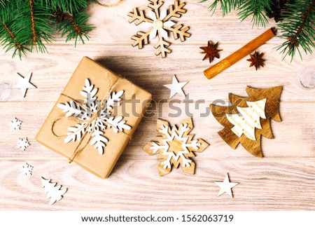 gift box in craft paper with Christmas decoration, twine rope, concept background, top view on wood table surface. Christmas ornaments and presents border with snowflakes and stars. Toned.