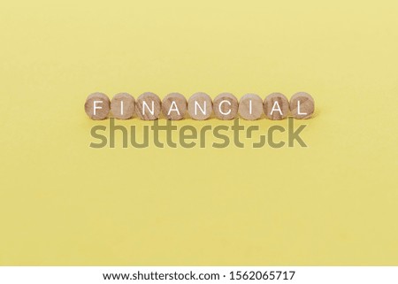 Financial text on wooden block on yellow background