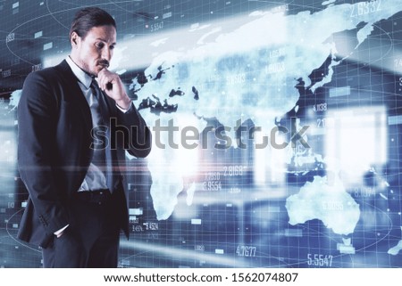 Thoughtful young businessman with glowing map on blurry office interior background. Data and interactive concept. Double exposure