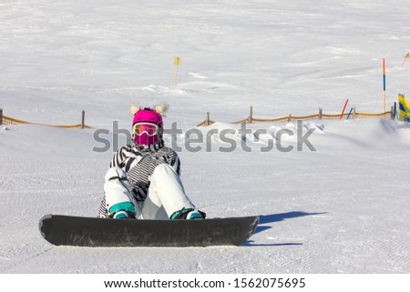 Snowboarding girl on the mountain slope