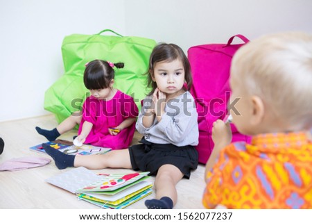 Group of little kids learning together while sitting in the kindergarten