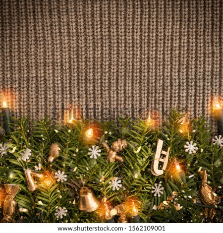 Christmas border on a dark background of a knitted sweater with a luminous garland