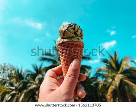 Close up hand holding ice cream with nature background, hello summer season, relaxation and lifestyle concept, vintage tone