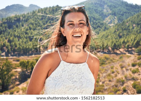 Young beautiful woman enjoying summer vacation on mountain landscape, traveler girl smiling happy