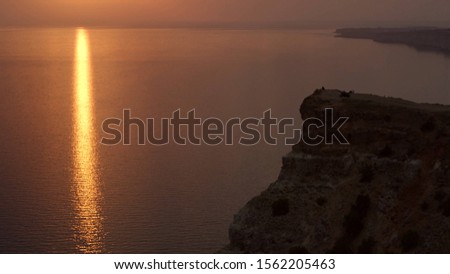 Sunset view at the seashore of cliffs and rocks. Shot. Top view of the sunset on the beach with rocks
