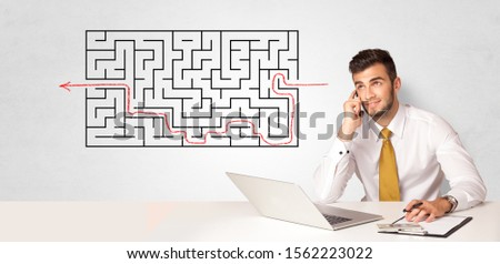Businessman presenting a maze on a wall