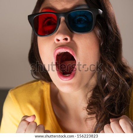 Expressive young woman watching 3d film in stereo glasses