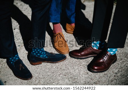 Groom's and groomsman feet with funny colorful socks. The men in stripy socks. Bright, vintage, brown shoes. Fashion, style, beauty. Royalty-Free Stock Photo #1562244922