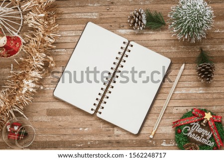 Top view of blank notebook on grunge wood  background with Christmas decorations. Mockup xmas background with notebook for wish list or to do list. Flat lay with copy space.