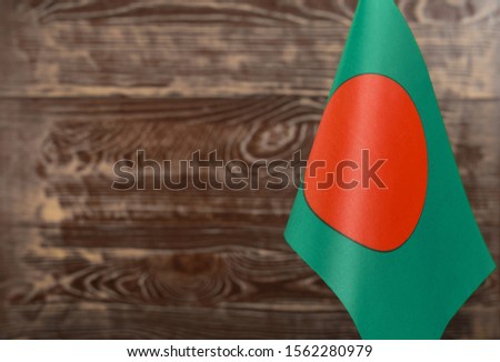 Fragment of the flag of the people's Republic of Bangladesh in the foreground blurred background copy space