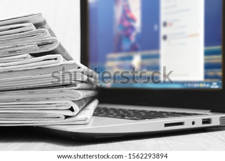 Newspapers and Laptop. Different Concepts for News -  Network or Traditional Tabloid Journals. Data Sources - Electronic Screen of Computer or Paper Pages of Magazines, Internet or Papers        