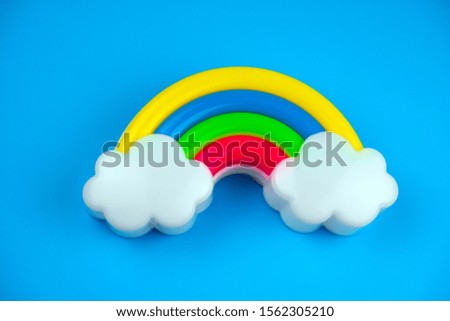 plastic rainbow with clouds on a bright blue background