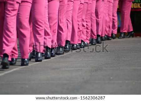 A number of police wives lined up neatly and wore pink uniforms